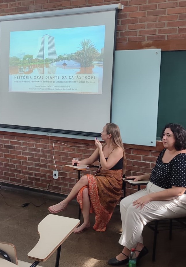 Clarissa Sommer e Bruna Xavier apresentando o trabalho “História Oral diante da catástrofe: desafios do Projeto Memórias das enchentes na Administração Pública Estadual, RS, 2024”.